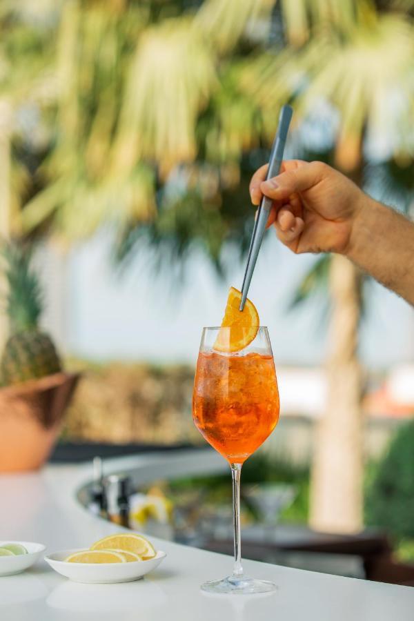 Hotel Mondrian Ad Dawhah Esterno foto A spritz being garnished with an orange slice